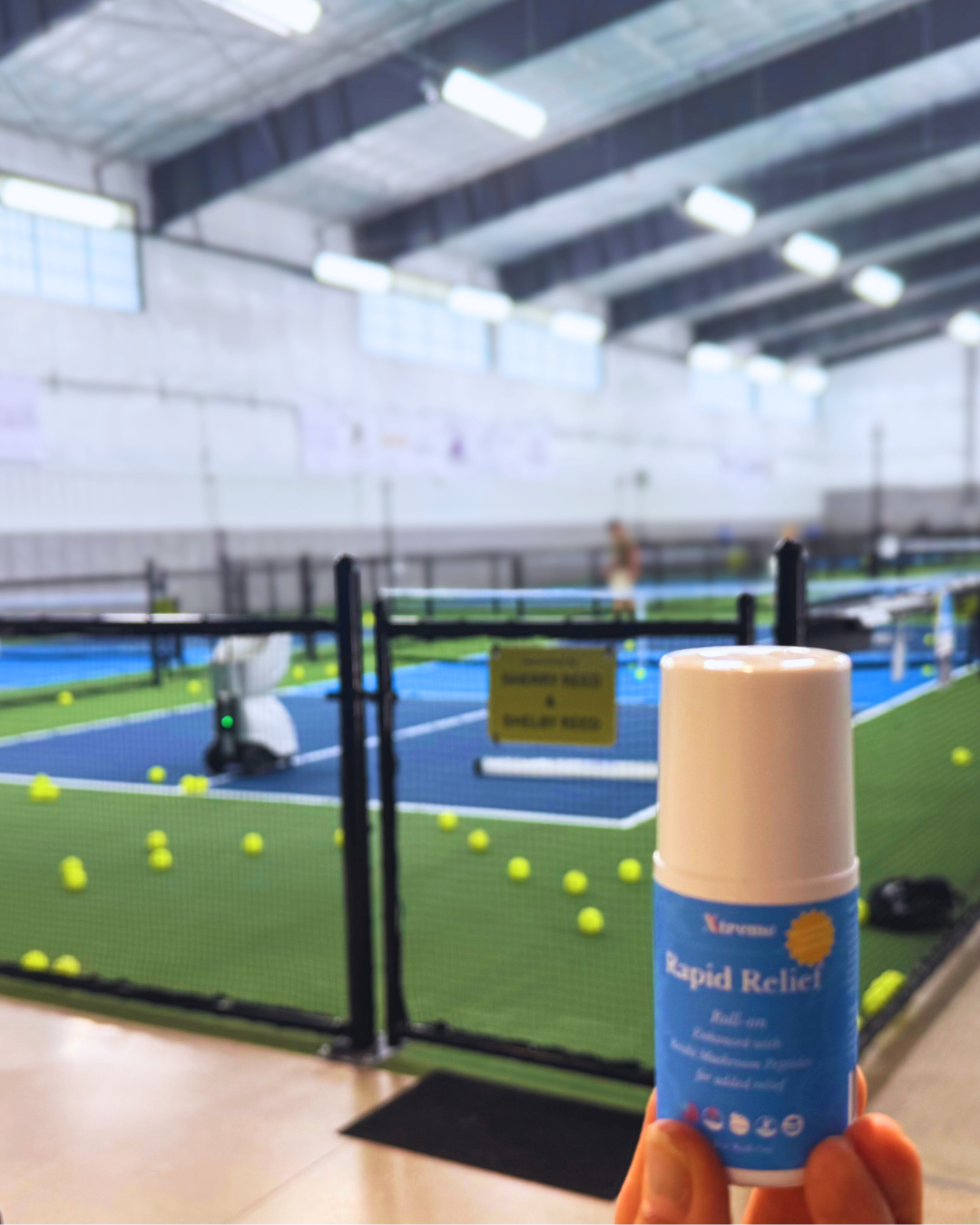 Xtreme Rapid Relief Roll-On held up at a pickleball court – USA-made natural pain relief with full-spectrum hemp, Arnica, and Menthol for active recovery.