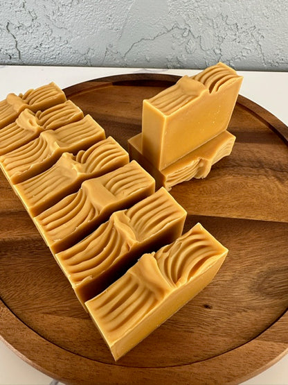 Golden Glow handmade soap loaf being sliced into bars – USA-made artisan soap with turmeric and citrus for brightening and refreshing skin.

