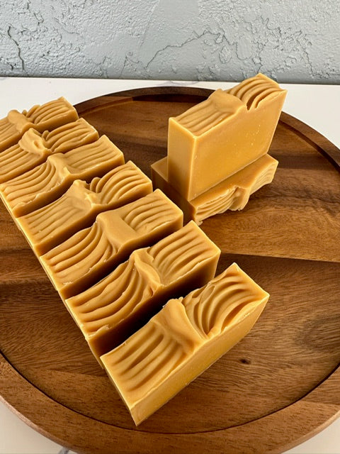 Golden Glow handmade soap loaf being sliced into bars – USA-made artisan soap with turmeric and citrus for brightening and refreshing skin.
