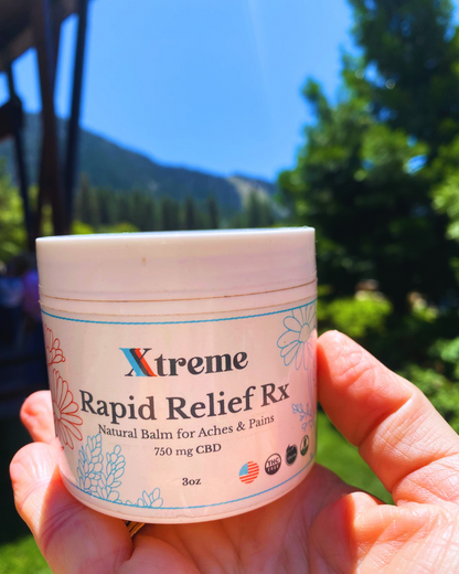 Xtreme Brands RX Rapid Relief Balm held with nature in the background – strongest doctor-trusted formula with full-spectrum hemp, Arnica, and Menthol for targeted muscle and joint relief.
