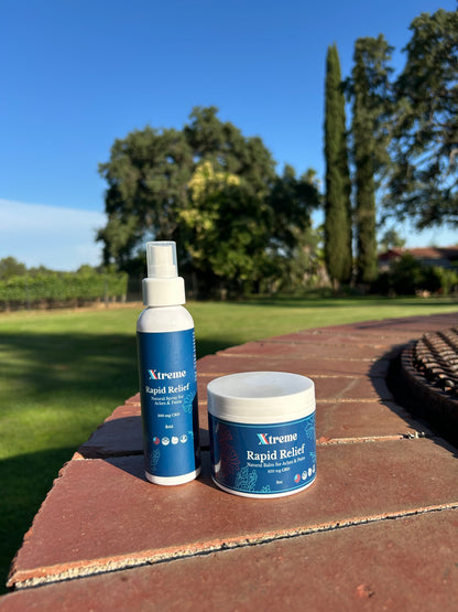 Xtreme Rapid Relief Balm and Natural Spray outdoors with trees in the background – USA-made, doctor-trusted hemp-derived CBD formulas with Arnica, Turmeric, and Willow Bark for everyday muscle and joint relief.
